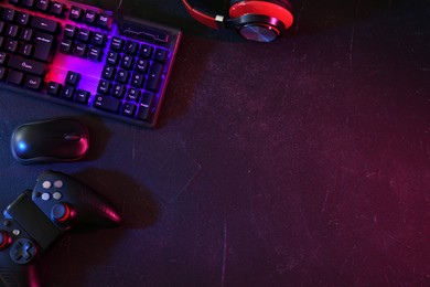 Photo of Modern RGB keyboard, mouse and video game controller on grey table, flat lay. Space for text