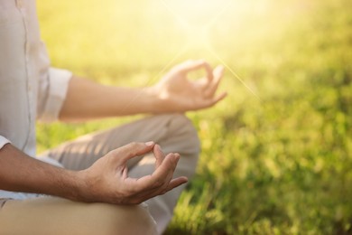 Man meditating outdoors on sunny day, closeup. Practicing yoga