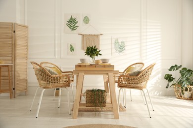 Stylish wooden dining table and chairs in room. Interior design