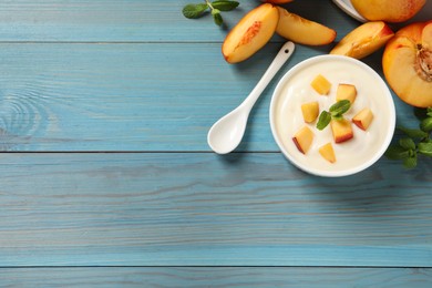 Delicious yogurt with fresh peach and mint on light blue wooden table, flat lay. Space for text