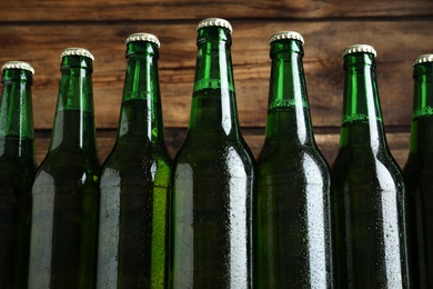 Photo of Bottles of beer on wooden background, closeup