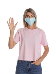 Woman in protective mask showing hello gesture on white background. Keeping social distance during coronavirus pandemic