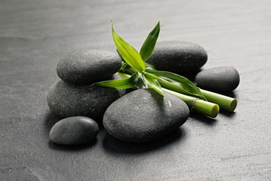 Spa stones and bamboo stems on grey table