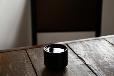 Photo of Cup of aromatic coffee on wooden table in cafe. Space for text