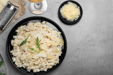 Delicious risotto with cheese on grey table, flat lay