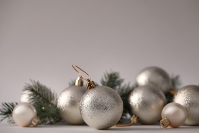 Beautiful Christmas balls and fir branches on grey background. Space for text