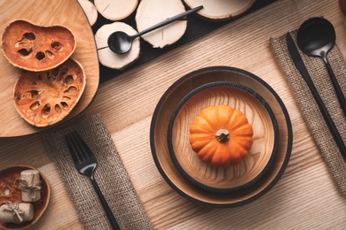 Photo of Autumn table setting with pumpkin on wooden background, flat lay