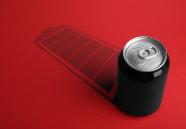 Energy drink and shadow in shape of fully charged battery on red background 