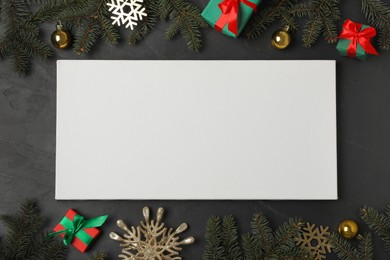 Flat lay composition with blank canvas and Christmas decor on black background. Mockup for design