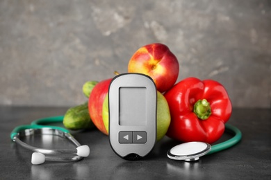 Digital glucometer, stethoscope, fruits and vegetables on table. Diabetes concept