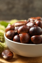 Fresh sweet edible chestnuts in bowl, closeup
