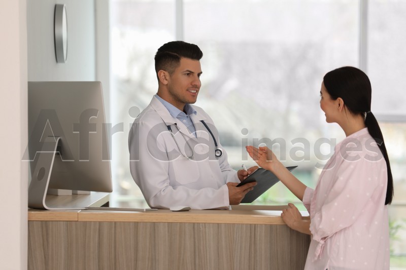 Photo of Doctor working with patient at reception in hospital
