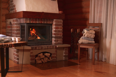 Fireplace with burning wood in room. Winter vacation