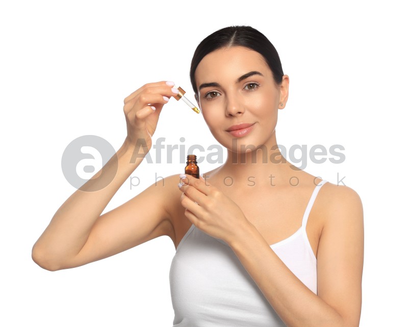 Young woman with bottle of essential oil on white background