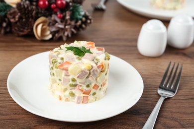 Traditional russian salad Olivier served on wooden table