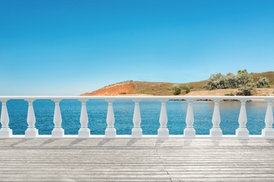 Image of Outdoor wooden terrace revealing picturesque view on sea under blue sky