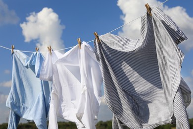 Clean clothes hanging on washing line against sky. Drying laundry
