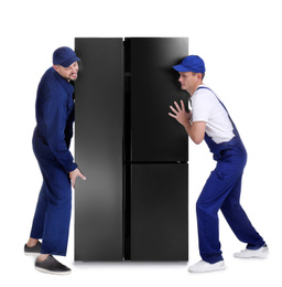 Professional workers carrying refrigerator on white background