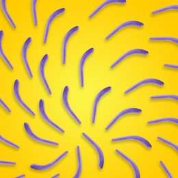 Violet boomerangs on yellow background, flat lay