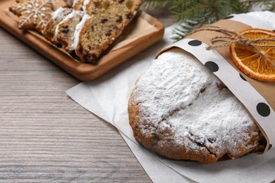 Decorated traditional Christmas Stollen on wooden table, closeup. Space for text