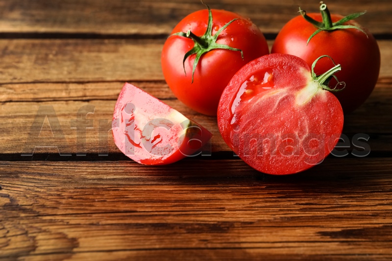 Photo of Fresh ripe red tomatoes on wooden table