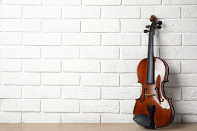 Classic violin near white brick wall. Space for text