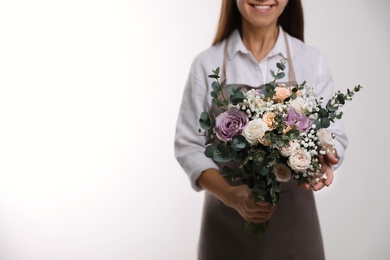 Florist holding beautiful wedding bouquet on white background, closeup