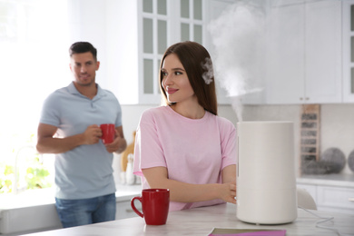 Couple in kitchen with modern air humidifier