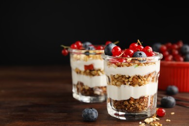 Delicious yogurt parfait with fresh berries on wooden table, space for text