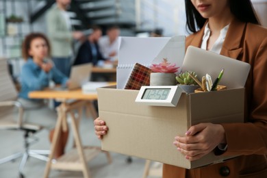 Young dismissed woman carrying box with stuff in office, closeup. Space for text