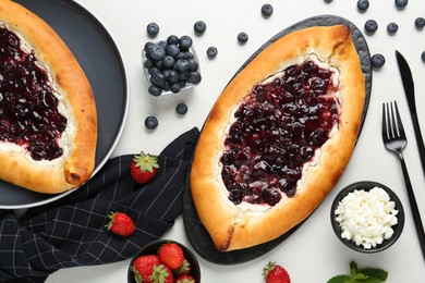 Photo of Delicious sweet cottage cheese pastry with cherry jam served on light table, flat lay