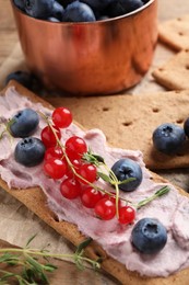 Tasty crispy crackers with cream cheese, thyme and berries, closeup