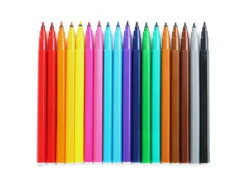 Many colorful markers on white background, top view. School stationery