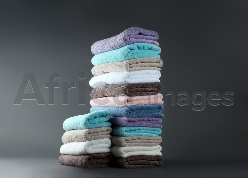 Different fresh soft terry towels on grey background