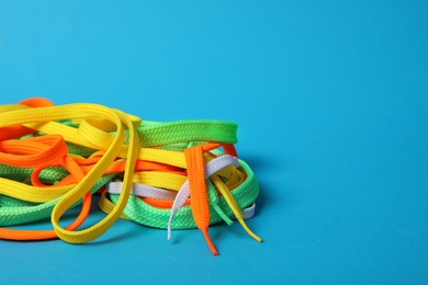 Colorful shoe laces on light blue background. Space for text