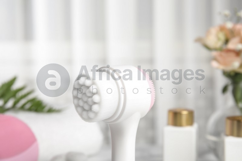 Photo of Modern face cleansing brush on blurred background. Cosmetic accessory