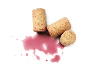 Bottle corks with wine stains on white background, top view