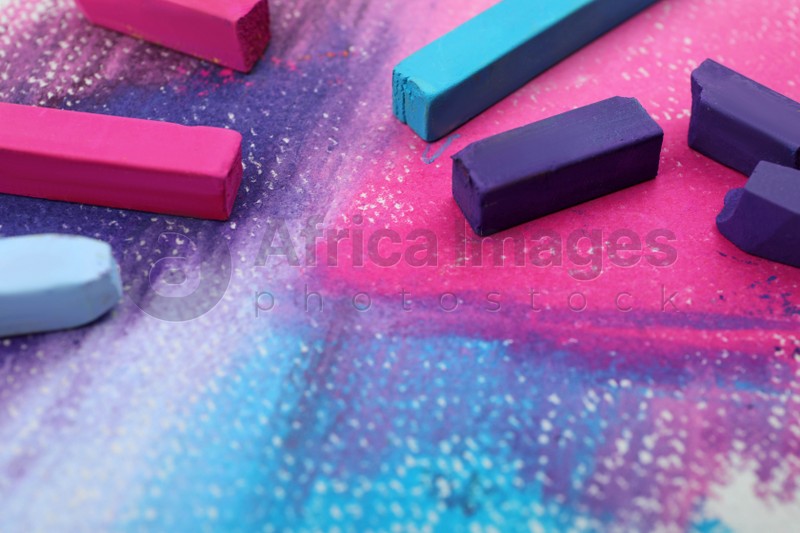Colorful pastel chalks on abstract painting, closeup. Drawing materials