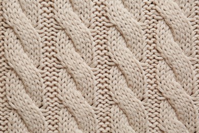 Beige knitted fabric with beautiful pattern as background, top view