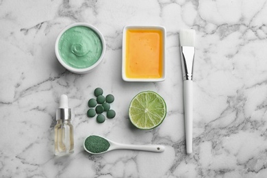 Photo of Flat lay composition with spirulina facial mask and ingredients on marble table