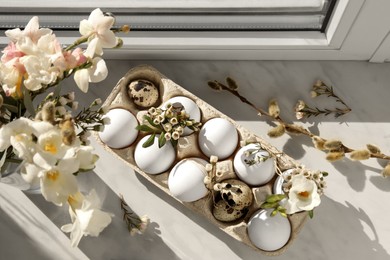 Photo of Festive composition with eggs and floral decor on windowsill indoors, flat lay. Happy Easter