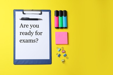 Clipboard with phrase Are You Ready For Exams and stationery on yellow background, flat lay. Space for text