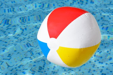 Inflatable beach ball floating in swimming pool, closeup