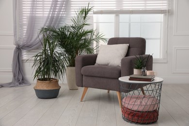 Comfortable place for rest with grey armchair near window indoors
