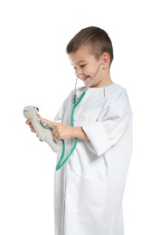 Cute child imagining himself as doctor while playing with stethoscope and toy on white background