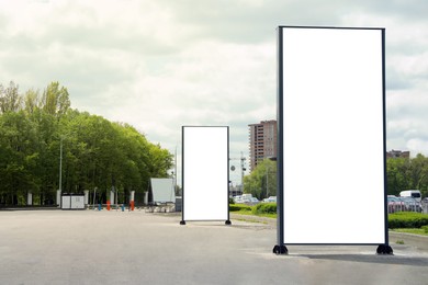 Blank advertising boards on sidewalk in city. Mockup for design