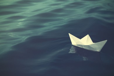 White paper boat floating on river. Retro photo effect