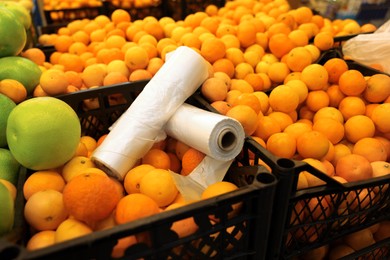 Photo of Plastic bags on crates with fruits in supermarket