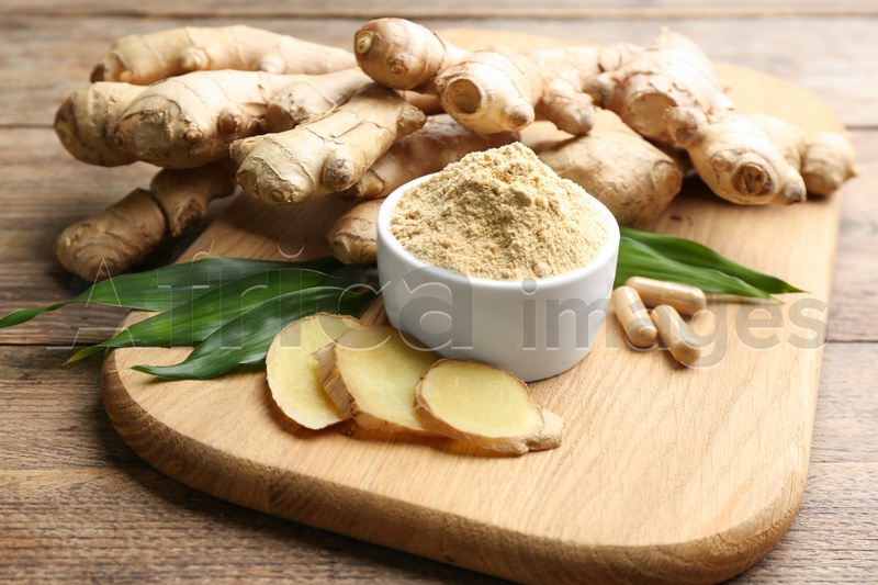 Photo of Dry, fresh and capsuled ginger on wooden table