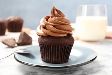 Delicious fresh chocolate cupcake on white marble table, closeup